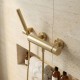 Mitigeur de douche avec douchette or sur mur en pierre beige